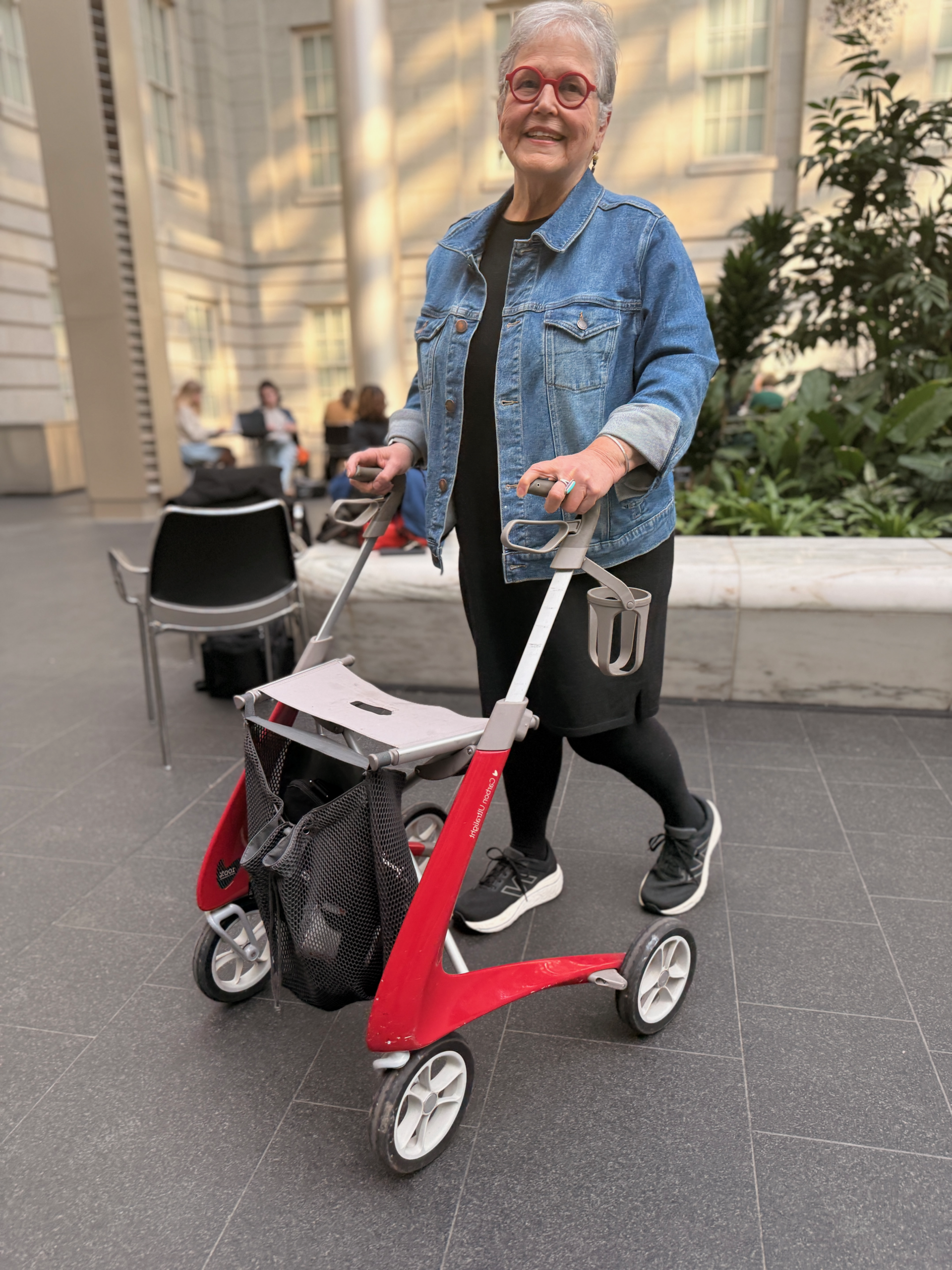 The author walking with her red rollator that she named Joy.