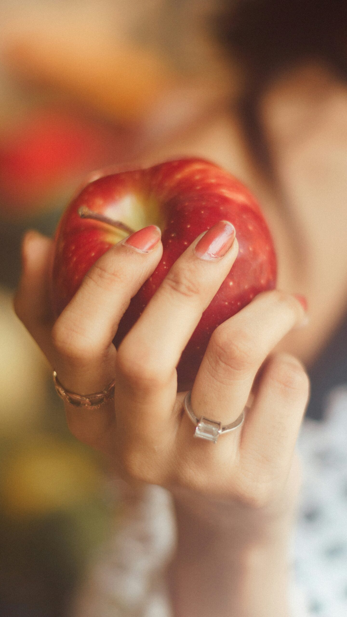 Hand holding an apple ready to eat it.