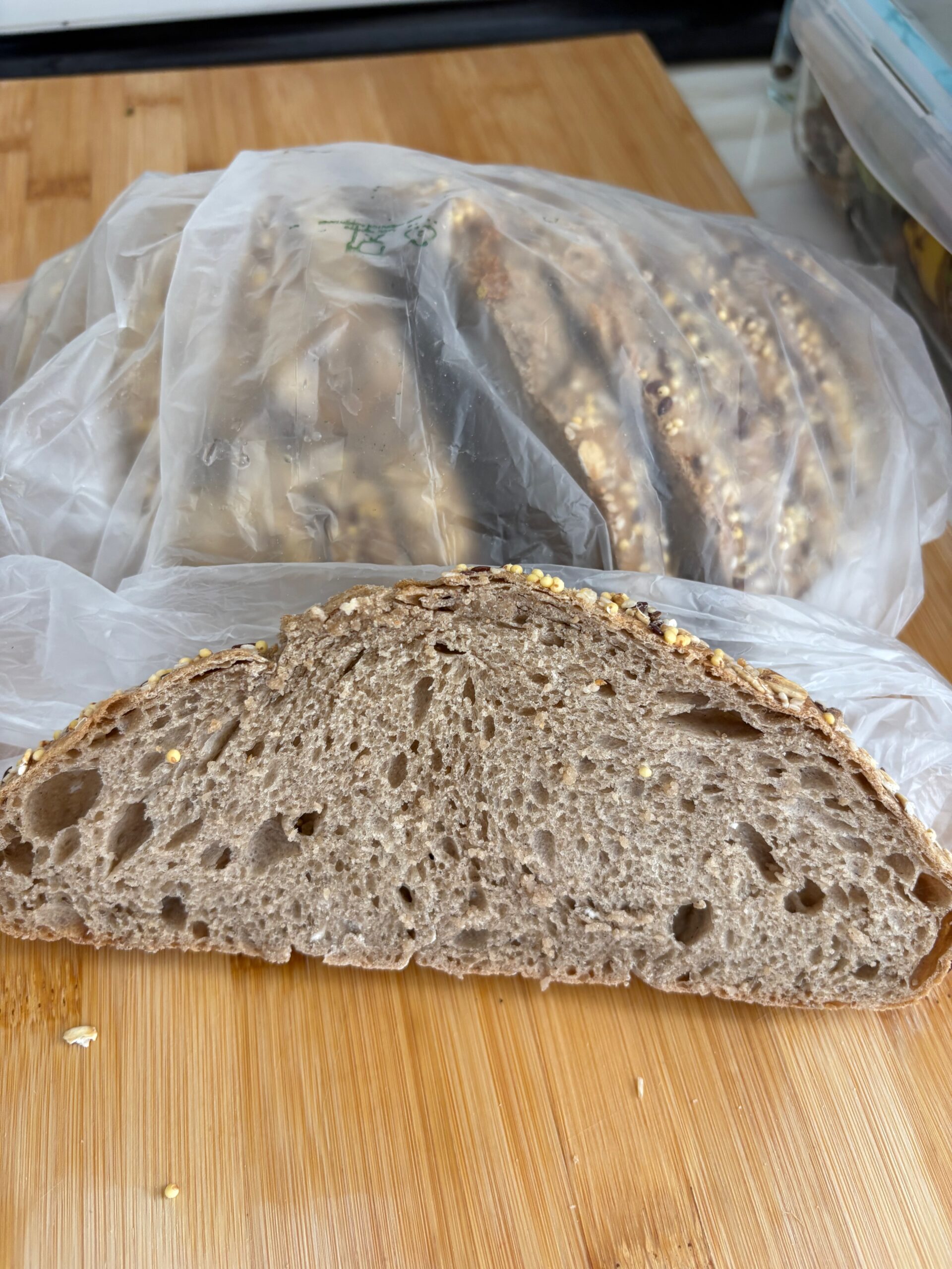 Fresh slice of 100% whole multi-grain bread with seeds. crumb soft and filled with holes, crust a little firm Looks delicious.